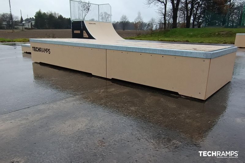 Quater z grindboxem na skateparku 