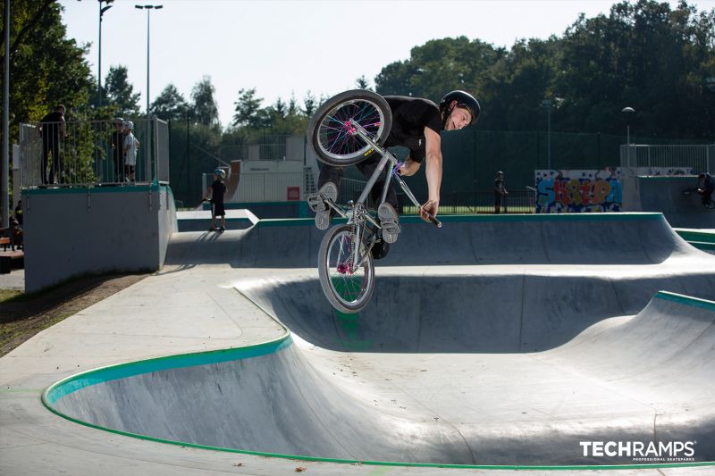 Rider na BMX wykonuje trick nad bowl'em w skateparku Zielonka