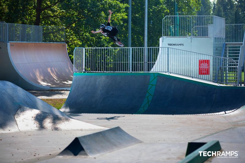 Skok na BMX na rampie vert w skateparku